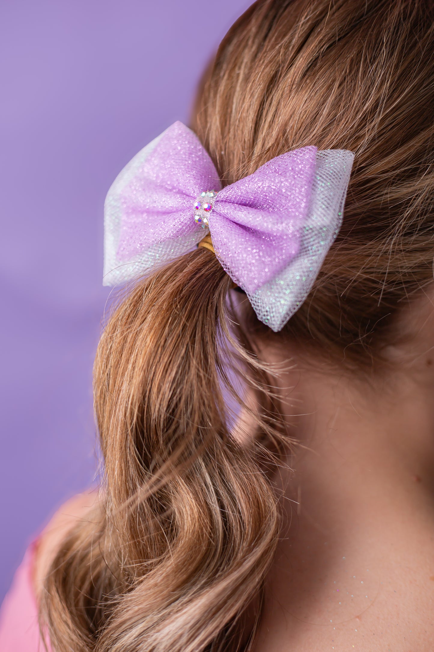 Two layer rhinestone dipped gymnastics hair bow worn in a child's hair, cbcsportswear