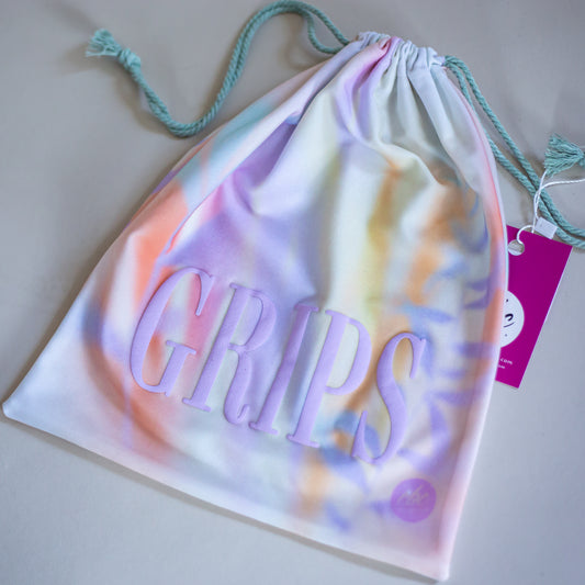 Watercolor print gymnastics grip bag by CBC Sportswear. Features a vibrant and colorful summery design with 'GRIPS' text in bold letters. Ideal for storing gymnastics grips and accessories. Made from durable, soft fabric with a drawstring closure for easy use.