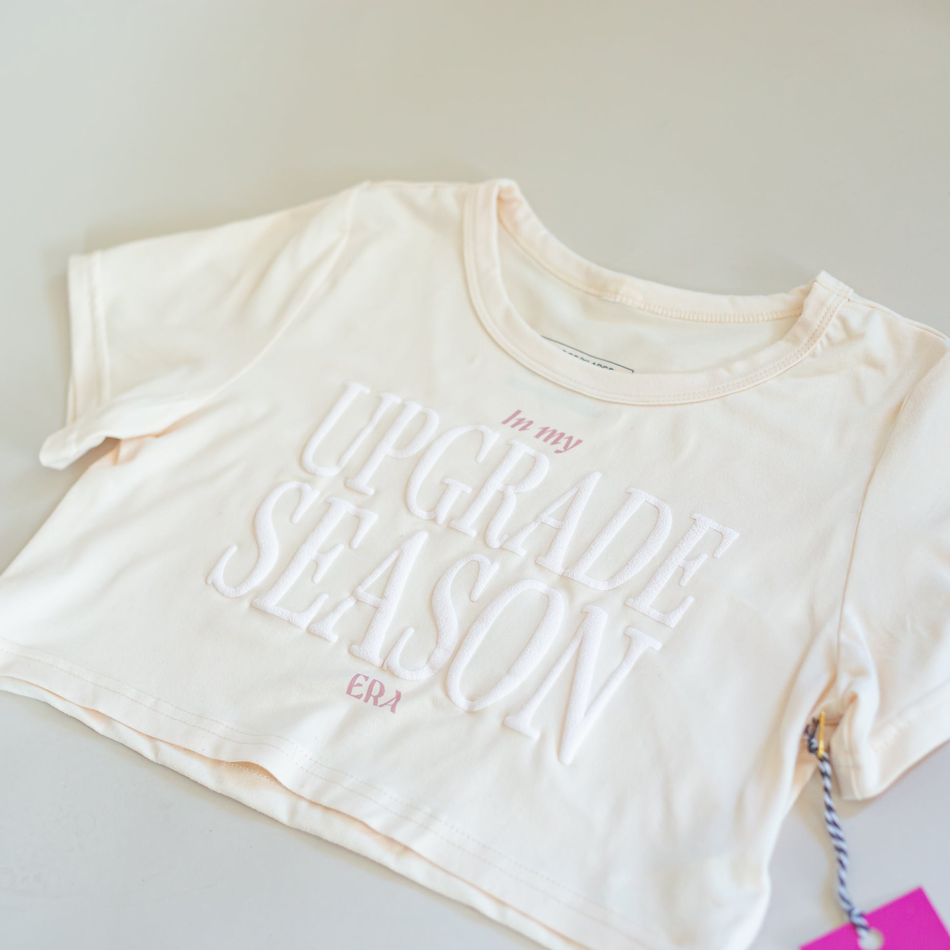 Beige crop top with 'In my Upgrade Season' text by CBC Sportswear. Made from soft, comfortable fabric, perfect for active wear. Ideal for young athletes and gymnasts looking for stylish and motivational apparel."